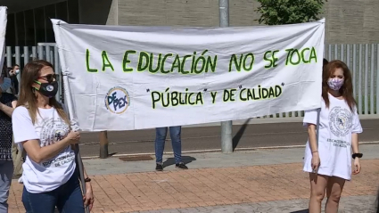 Dos manifestantes portan un pancarta en la que puede leerse 'La Educación no se toca'.