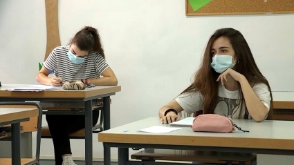 Dos alumnas en sus mesas y atendiendo a clase