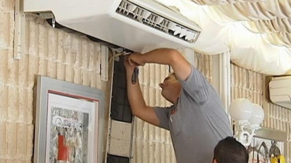 Dos técnicos instalan un aire acondicionado