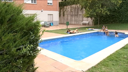Varios vecinos de una comunidad de propietarios se bañan en la piscina común
