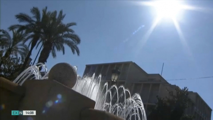 Sol veraniego sobre fuente y palmera