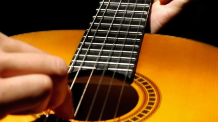 manos tocando una guitarra española