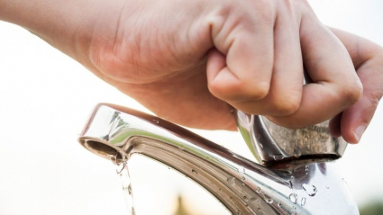 mano masculina cerrando un grifo