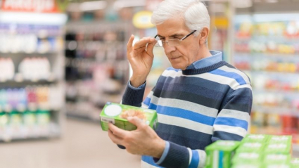 hombre mirando el etiquetado de un producto en el supermercado