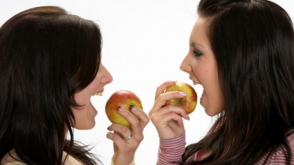 Adolescentes comiendo manzanas