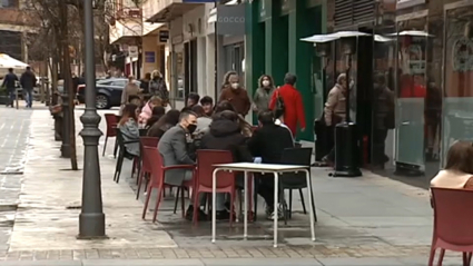 Una de las calles de Cáceres con bares y clientes en sus terrazas