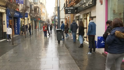 Clientes haciendo colas antes de la apertura de las tiendas en la calle Menacho de Badajoz
