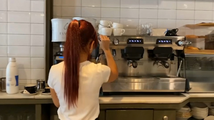 Camarera preparando un café en una cafetería