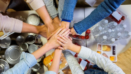 manos unidas formando equipo con alimentos