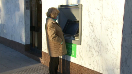 Mujer intentando sacar dinero de un cajero automático