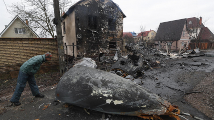 Un hombre mira los escombros de un avión militar que fue derribado durante la noche en Kiev, Ucrania, el 25 de febrero de 2022. Las tropas rusas ingresaron a Ucrania el 24 de febrero, lo que llevó al presidente del país a declarar la ley marcial.
