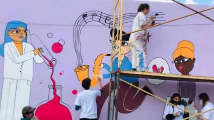 Inma Pnitas y más personas dibujando un mural musical
