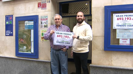 Dueños de la Administración Número 4 de Badajoz mostrando el cartel del premio de la Primitiva
