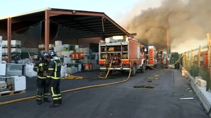 Bomberos trabajan en la extinción del incendio declarado en la planta de Lobón