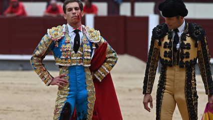 El diestro Ginés Marín (i), tras sufrir un revolcón con su primero de la tarde durante la corrida de la Feria de San Isidro hoy en la plaza de Lasa Ventas, en Madrid.