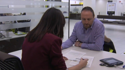 Un cliente contratando un préstamo hipotecario en una sucursal bancaria.