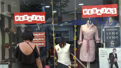 Escaparate de un comercio de ropa con carteles de rebajas