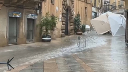 Sombrillas tiradas en una calle debido a la lluvia