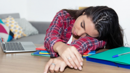 Adolescente dormida sobre sus deberes