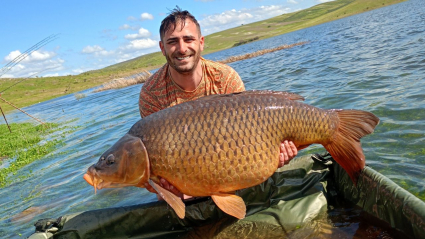 Jonathan Murillo Rubio junto a la carpa de casi 30 kilos que ha capturado en el embalse de Orellana