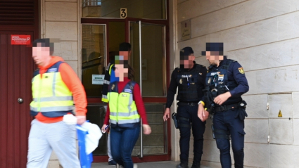 Agentes de la Policía Nacional abandonan el edificio en el que se ha producido el suceso