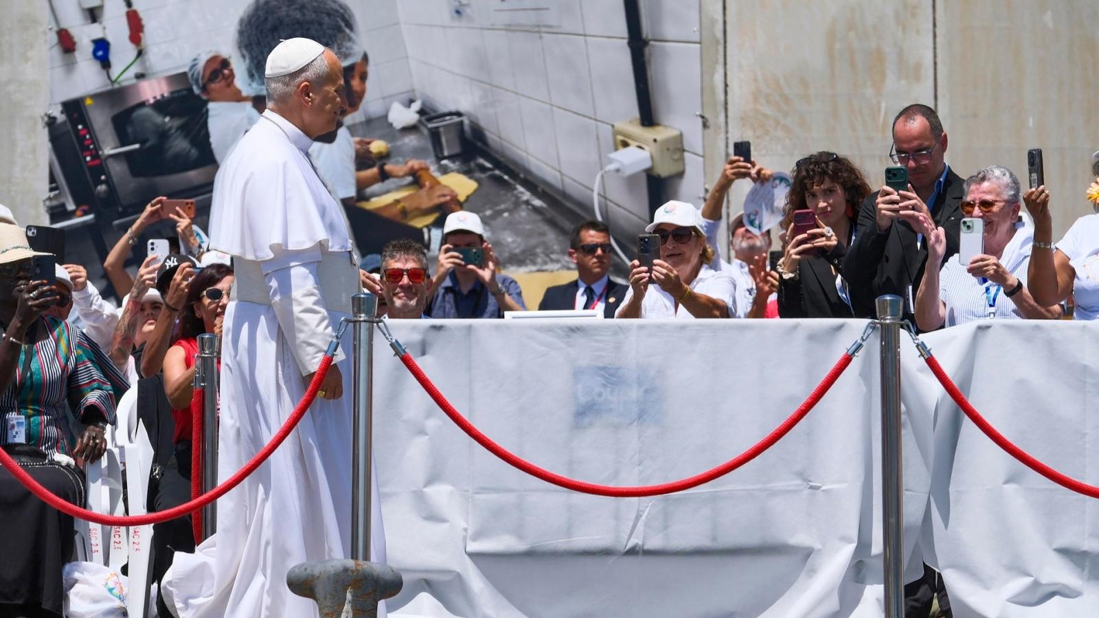 El papa León XIV durante la ofrenda floral en recuerdo de los migrantes muertos en la travesía durante el encuentro con más de un millar de inmigrantes de África, América Latina.