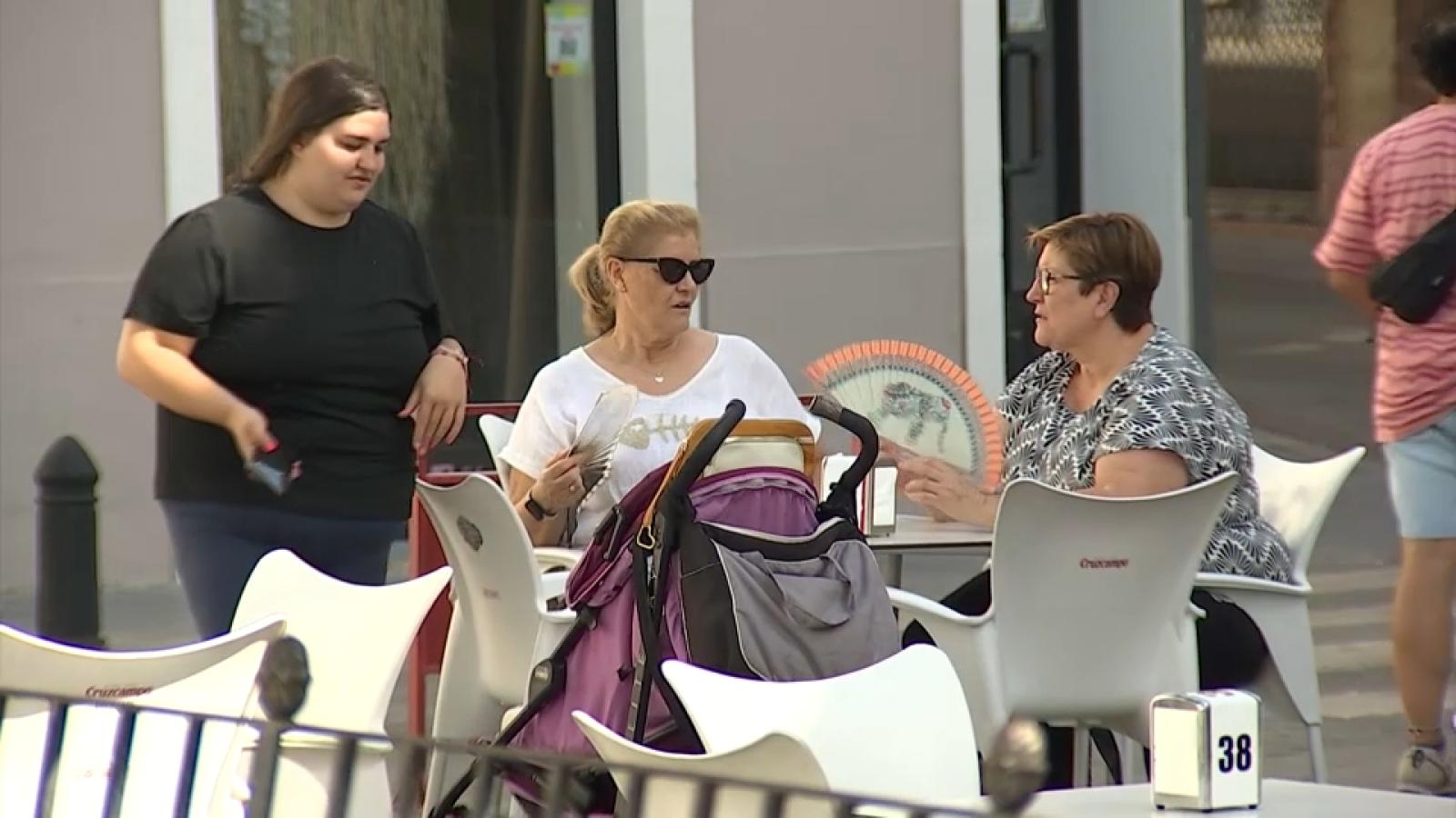 Mujeres con abanico en una terraza, en una imagen de archivo