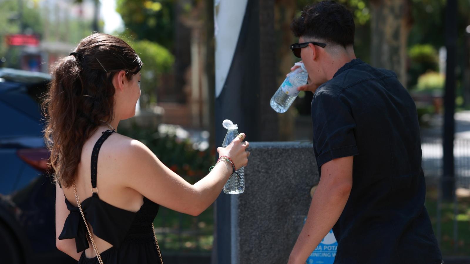 Una pareja bebe agua durante la ola de calor