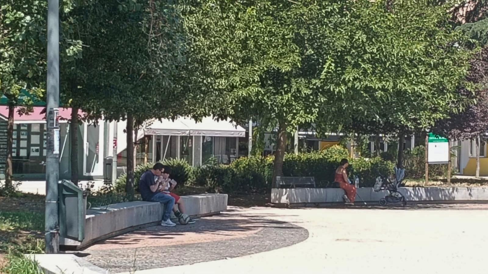 Gente sentada a la sombra en un parque en Badajoz resguardándose del calor
