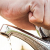 mano masculina cerrando un grifo