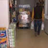 Dueño de tienda de alimentación vendiendo agua embotellada