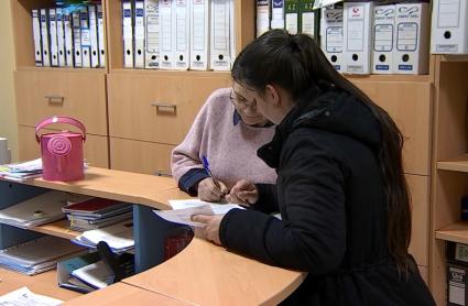 Una madre rellenando la solicitud de escolarización