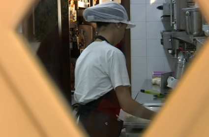 Mujer trabajando en cocina de bar