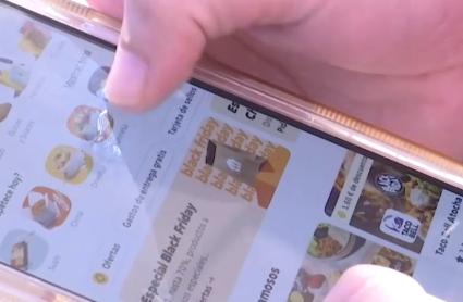 Una joven pide comida a domicilio a través de una aplicación móvil