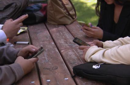 Jóvenes utilizando teléfonos móviles - Imagen de archivo.