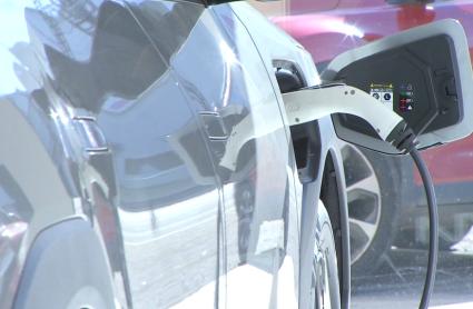 Un coche eléctrico cargándose dentro de un concesionario