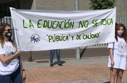 Dos manifestantes portan un pancarta en la que puede leerse 'La Educación no se toca'.