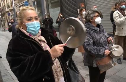 Pequeños comerciantes de la calle Menacho de Badajoz protestan cacerola y cazo en mano contra el cierre de sus tiendas.
