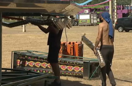 Feriantes montando las atracciones en el ferial de Caya en Badajoz.