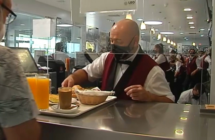 Un camarero atiende a clientes en el área de servicio Leo de Monesterio 