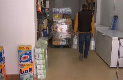 Dueño de tienda de alimentación vendiendo agua embotellada