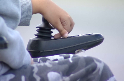 Niño en silla de ruedas eléctrica