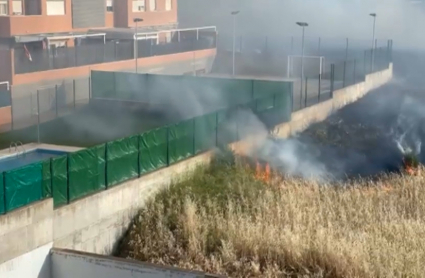 Una dotación de bomberos sofocando el incendio de pastos