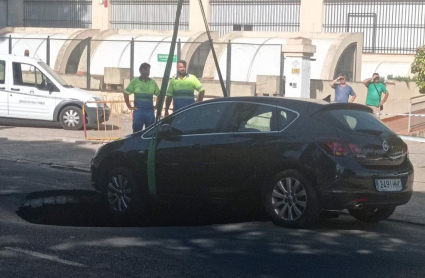 Coche remolcado tras estar a punto de caer en un socavón